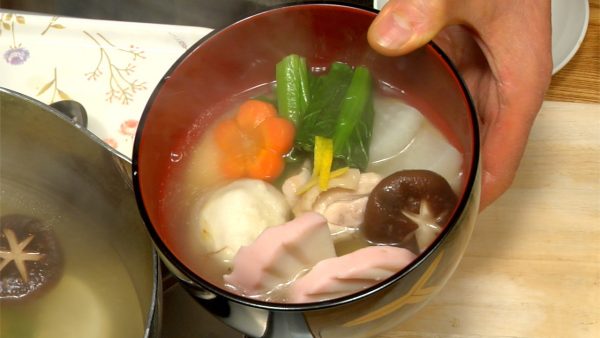 Décorez avec le zeste de yuzu. Enfin, versez la soupe ozoni chaude sur les ingrédients.