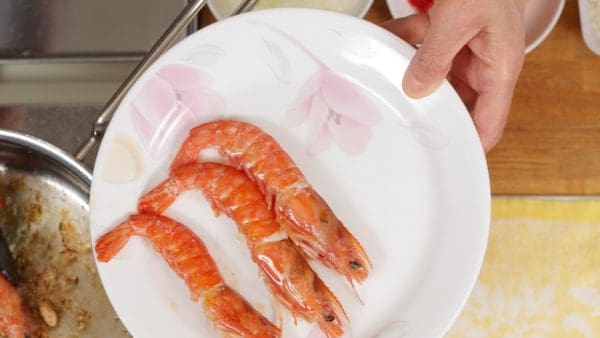 When the other sides of the prawns also brown, save them on a plate. If the ingredients stick to the bottom, cool the pan on a dampened kitchen towel. This will help to detach them from the pan.