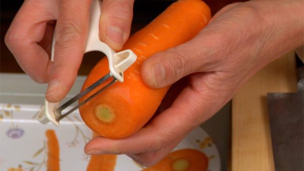 Maintenant, coupez les légumes. Coupez les bouts de la carotte et épluchez-la avec un économe.
