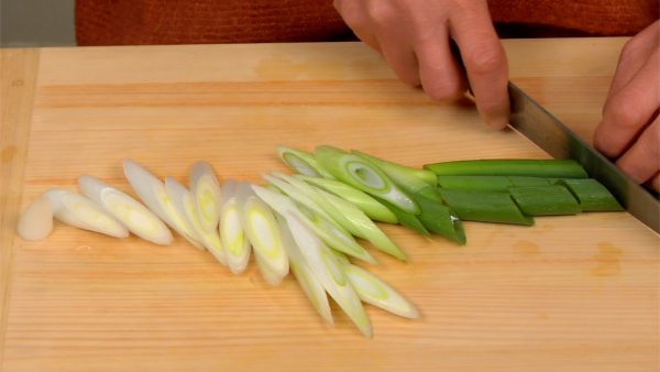 Slice the long green onion using diagonal cuts.