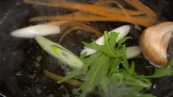 Để cà rốt và nấm hương vào nồi. Sau đó, thêm hành boa rô và rau mù tạt Nhật Bản (mizuna)