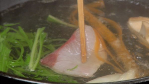 Now, using a pair of chopsticks, stir the yellowtail in the hot broth.