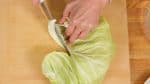 從捲心菜葉上取出莖。把莖切成薄片，以便以後可以在炒菜中使用。將葉子切成小塊。