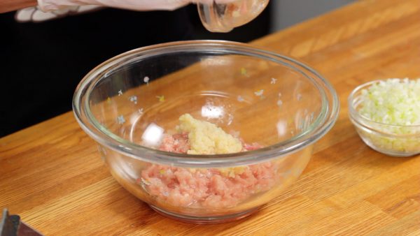 Préparez les boulettes de poulet. Placez le poulet haché dans un bol, et ajoutez le sel, le poivre, le sake, et le gingembre haché. Malaxez la viande avec vos mains pour bien mélanger. 