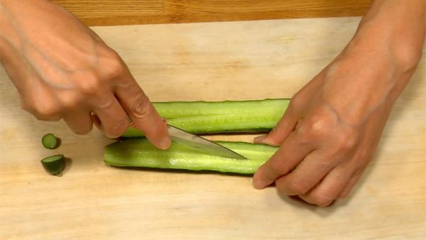 Let's cut the ingredients for Maki Sushi. Remove both ends of the cucumber. Cut it lengthwise and make 4 to 6 cucumber sticks.