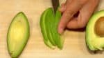 Peel the avocado and cut it into thin slices.