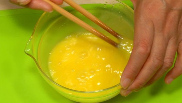 現在來做蛋捲吧。在碗裡打入兩個雞蛋。加入糖和鹽，然後打勻成蛋液。