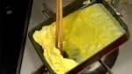 迅速重新往鍋內倒入油，檢查油溫，然後再倒入三分之一的蛋液。再把雞蛋鋪在第一層煎蛋的下面。