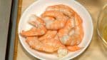 將半湯匙的壽司醋倒在事先煮好的蝦仁上面，然後把蝦仁翻面浸泡均勻。