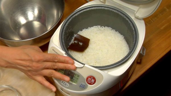 When the rice is cooked, remove the dashi kombu kelp. Scrape off the rice with a paddle.