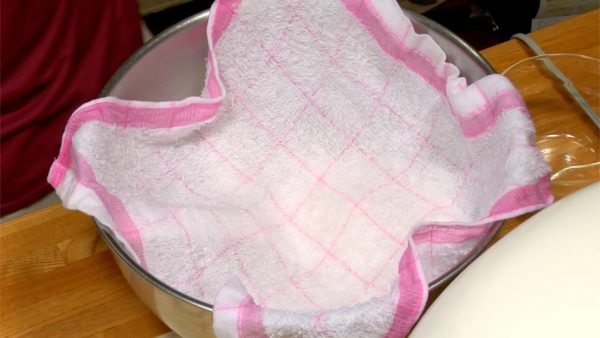 用濕的廚房用毛巾蓋住壽司米，保持米的濕潤。