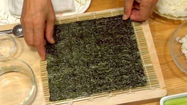Put a shiny side of toasted nori on a bamboo mat.