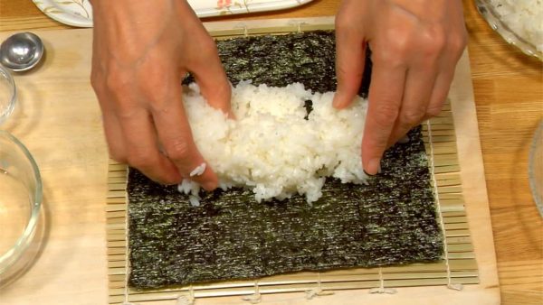 把米飯放在海苔上。米飯要平鋪在海苔上，但要在底端留1.5厘米的空隙。