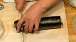 把刀子的兩邊都沾濕，然後切掉太卷壽司的兩頭。每切一下就用濕毛巾擦一下刀子，防止米飯粘在刀上。總共能切出8塊太卷壽司來。