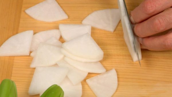 Remove the outer skin of the daikon radish with a peeler. Quarter the daikon and slice it into quarter moons.