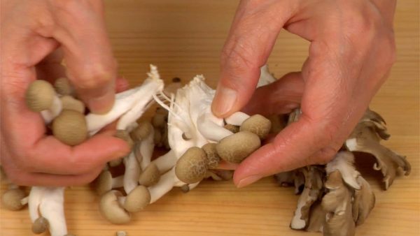 With your hands, separate the shimeji mushrooms and the maitake mushrooms into bite-size pieces.