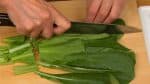 Das Wurzelende des Komatsuna Spinats entfernen und diesen in 4 cm lange Stücke schneiden.Als Ersatz eignet sich jedes blättrige Gemüse mit mildem Geschmack. Beispielsweise Bok choy, Mizuna oder gekochter Spinat.