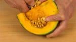 With a spoon, remove the seeds from the kabocha squash.