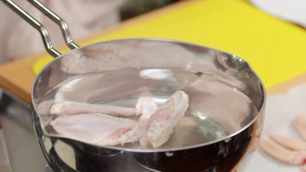 Place the chicken wings into a large pot of boiling water.