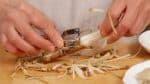 Next, shave the burdock root with a peeler. This will help to cook the firm root quickly.
