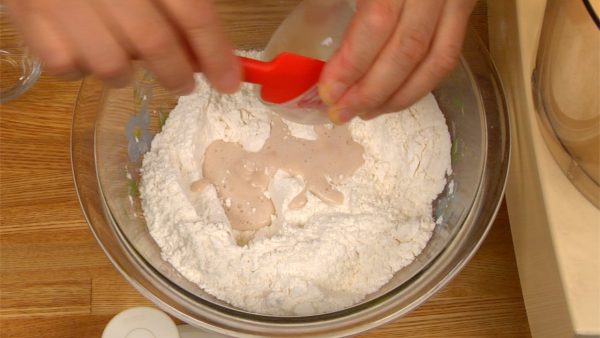 Adicione o fermento dissolvido à mistura de farinha.