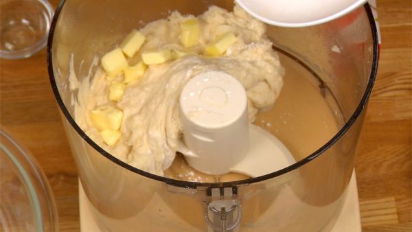 Cubra suas mãos com farinha e achate a massa, colocando a manteiga entre ela.