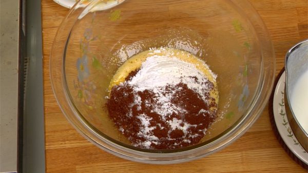 Mettez la farine à gâteau (T45), la fécule de maïs et le cacao en poudre dans une passoire fine. Tamisez les poudres ensemble et ajoutez-les au mélange d’œufs dans le bol. 