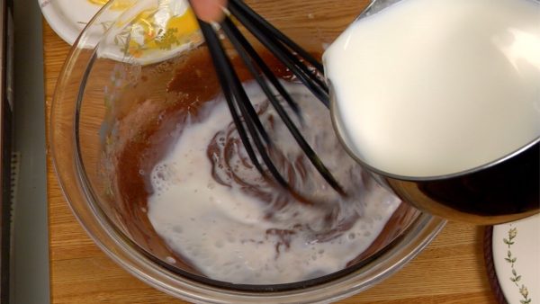 Ketika tepungnya sudah sudah tercampur merata, masukkan sisa susu panas sedikit demi sedikit selagi mengaduk.