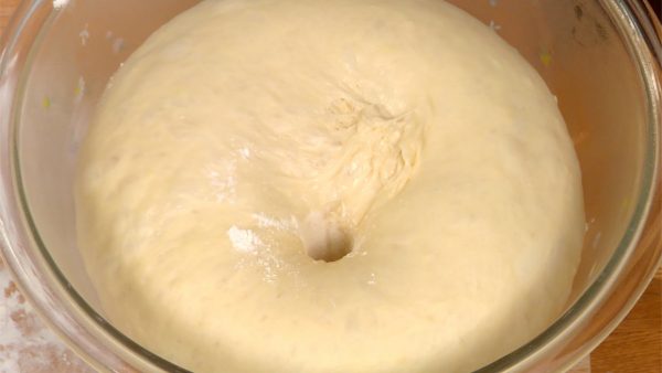 Maintenant, la pâte a doublé de volume. Pour vérifier si la pâte a complètement gonflée, plongez votre doigt dans la pâte pour faire un petit trou. Farinez votre doigt et plongez-le dans la pâte pour faire un petit trou. Si le trou disparaît rapidement, la pâte a encore besoin de gonfler. 