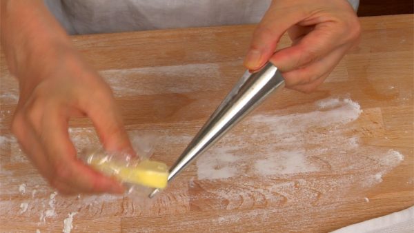 Vamos moldar a massa em formato de corneta. Unte cada molde de cone com manteiga.
