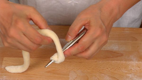 En commençant à 2cm (0.8 pouce) au dessus de la pointe des moules à cornet, enroulez la pâte autour des moules.