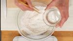 Đầu tiên, chúng tôi sẽ làm dango (bánh dày mochi ngọt). Thêm một nhúm muối vào bột mì đa dụng và trộn nó bằng đũa. Thêm nước từng chút một và trộn bột vào. Nếu bạn hết bột mì đa dụng, bạn có thể trộn bột bánh bông lan với một lượng bột bánh mì tương đương trong công thức này.