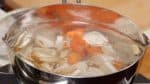 Maintenant, faites précuire les ingrédients. Ajoutez la bardane, le taro, le daikon et la carotte dans une grande casserole d'eau bouillante. Laissez-la bouillir à nouveau et faites cuire environ 1 minute.