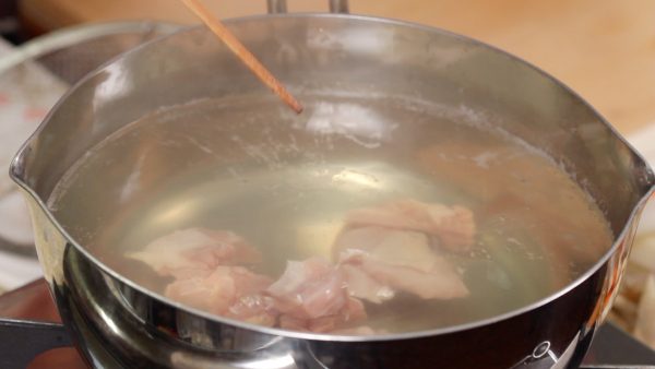 Turn off the burner and place the skinless chicken thigh into the same pot of hot water. The meat should be cut into bite-size pieces beforehand.