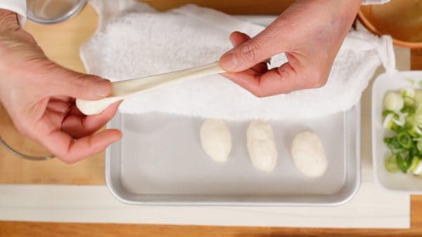 Now, shape each dango into a noodle-like strip. Gradually pull the edge to stretch the dango.