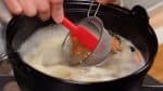 Ensuite, ajoutez la moitié du miso dans le bouillon. Dissolvez le miso dans une petite passoire pour éviter les grumeaux.