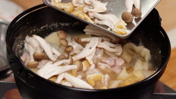 Now, add the chicken, aburaage, thin deep-fried tofu, and shimeji mushrooms.