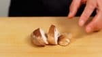 Retirez le pied des champignons shiitake. Coupez le chapeau en 3 à 4 tranches en biais. 