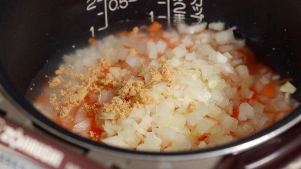 First, cook the rice with a slightly less amount of water. To the rice, add the carrot, onion and the crumbled chicken bouillon cube.