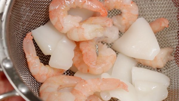 Now, let’s cook the white sauce. Rinse the seafood under running to help it thaw. Rinsing the seafood under running water will help it to thaw.