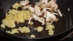 Frite bem a cebola até que esteja completamente cozida como mostrado. Agora, adicione os cogumelos shiitake e shimeji e continue a fritar.