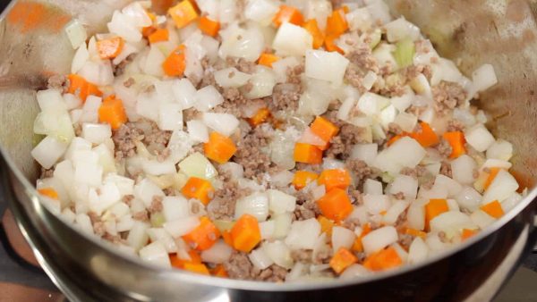 Assaisonnez de sel et poivre. Continuez de faire revenir la carotte et l'oignon pour un total de 4 à 5 minutes. 