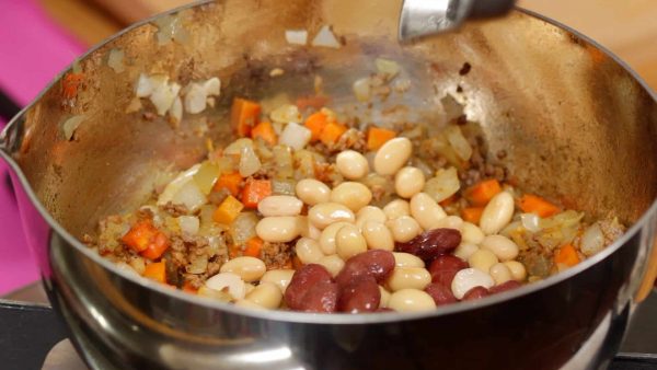炒めて香りを立たせ水、大豆と赤いんげん豆を加えます。