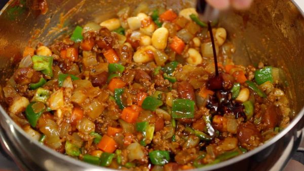 Maintenant la sauce est épaisse. Le poivron est cuit et a une texture brillante. Enfin ajoutez un filet de sauce soja. C'est l'ingrédient secret pour relever le goût de ce curry. 
