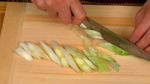 Vamos cortar os ingredientes. Corte a cebolinha comprida em pedaços de 7 a 8 mm (0.3") usando cortes diagonais.
