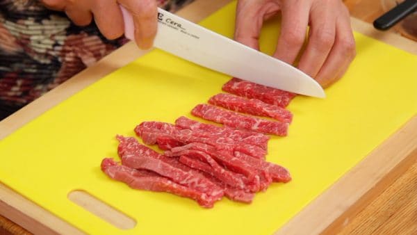 Now, cut the slices of beef steak into 7 to 8mm (0.3") strips. Place the beef onto a plate.