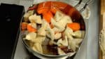 野菜を調理します。鍋にごぼう、こんにゃく、里芋、昆布、にんじん、水煮たけのこ、戻した干し椎茸、レンコンを入れます。だし汁を加えて火をつけます。