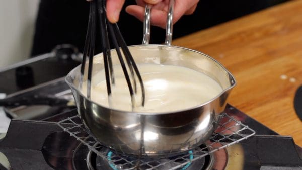Turn the heat to medium-low, and continue mixing it with a balloon whisk.