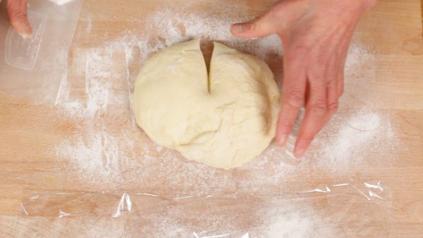 With a scraper, cut halfway through the dough on the side closest to you.