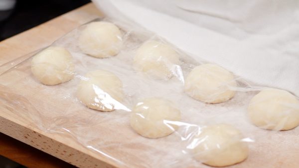 Line up the dough balls, and cover them with plastic wrap.